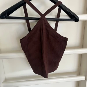 Mörkbrun topp från Gina - Snygg topp med kryss framtill. Mycket bra skick!