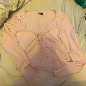 Långärmad topp - Kroppad långärmad topp från Gina, har slits vid båda ärmarna. Knappt använd 