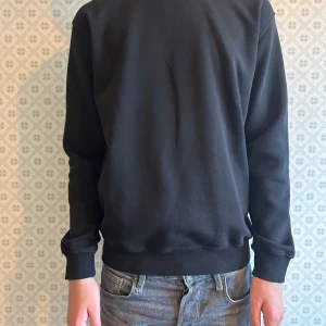 Svart Sweatshirt  - Tja säljer en svart sweatshirt från Kappahl i storlek 170 då den är för liten ny pris är 300kr men säljer den för 189 om du vill köpa denna med en grå eller båda två går det bra har du några frågor är det bara att höra av sig mvh Levi!