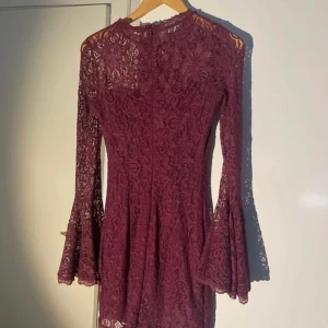 Klänning  - Spetsklänning med lite vidare ärmar. Vinröd/plommonlila