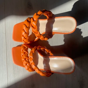 Orange klackar - Orange högklackar med rep design. Som ni ser på sulorna (bild 5) är skorna inte använda och i mycket bra skick.  (Frakt tillkommer, i andra finns möjlighet att mötas upp i Stockholm)