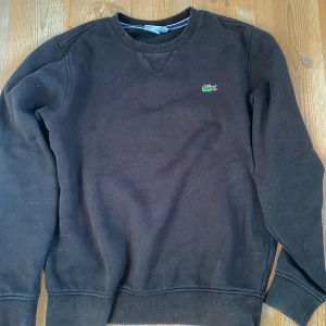 Lacoste tröja - Riktigt fet svart lacoste tröja. Är i perfekt kondition. Size S. Bara skriv om du undrar något 🤩