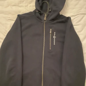 Hoddie  - Säljer min mörk blåa sail racing hoddie då den inte kmr till någon användning längre. Den är i bra skick och i st 170 vilket motsvarar typ st s!