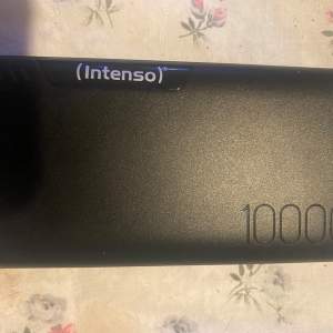 Intenso Powerbank P10000 med en kapacitet på 10000 mAh/37.0 Wh. Den har DC-ingång, USB-C-ingång, microUSB-ingång, USB-C-utgång och USB-A-utgång. Kabel till powerbank medföljer Oanvänd 