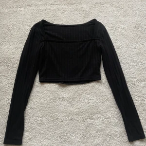 Fest topp - Säljer min svarta crop top med snygg urringning, perfekt till fest!