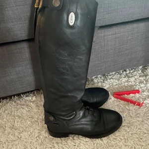 Svarta ridstövlar med snörning - Hej! Säljer mina ridstövlar då de blivit för små. Stövlarna är i bra skick, jag har varit noggrann med att ta hand om dem. Perfekt för dig som söker ett par fina och välskötta ridstövlar!  Skriv till mig om minsta fundering☺️Mvh Olivia
