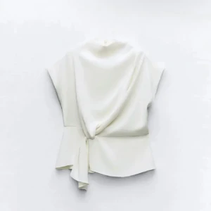 Vit omlottopp - Säljer en stilren vit omlottopp med knytning i sidan. Toppen har en elegant och enkel design som passar perfekt för både vardag och fest. 