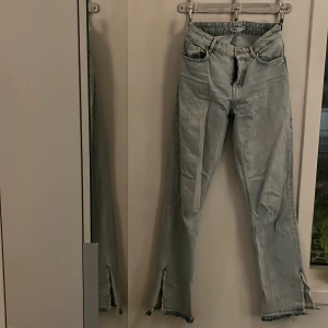 Ljusa jeans från Zara - Snygga ljusblå jeans från Zara med mid midja och raka ben. Byxorna har slitna detaljer vid fållen och en slits på sidan av benen. 