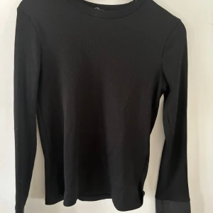 Svart ribbad tröja från Zara - Snygg svart ribbad tröja från Zara med långa ärmar och stilrena detaljer. Perfekt för fest och casual