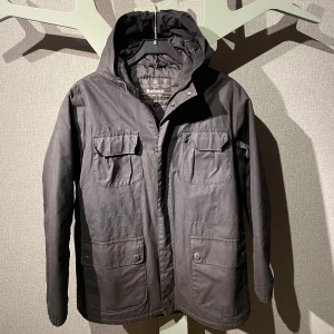 Svart jacka från Barbour - Säljer en stilren svart jacka från Barbour med luva. Barnstorlek är xxl men passar vuxen storlek S. Bra vinterjacka!🤩 Nypris 1800:-
