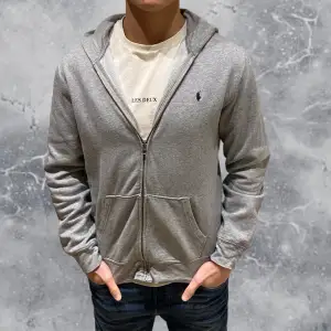 •Ralph Lauren full-zip hoodie grå. Skick: 8/10, Inga skador! Storlek: XL 18/20 kids = XS. Modell: 173 cm, 63 kg. Sitter bra på modell som vanligtvis bär XS/S. •Mått | axel-neråt: 62 cm, Bredd: 48 cm. Authentic: ✅. Hör av dig vid frågor eller funderingar, mvh Hessler’s;)