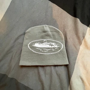 Cortiez mössa - Säljer en stilren grå cortiez mössa . Perfekt för kyliga dagar och passar till de flesta outfits. Mössan är i bra skick och har en mjuk och bekväm passform.