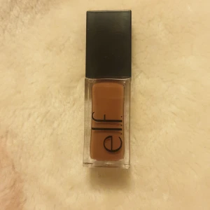 Glow Radiant Lip Oil från e.l.f. - Säljer en Glow Radiant Lip Oil från e.l.f. i en snygg, neutral nyans. Perfekt för att ge läpparna en glansig och återfuktad look. Kommer i en praktisk liten flaska med svart lock, lätt att ta med sig överallt. Perfekt för både vardag och fest!
