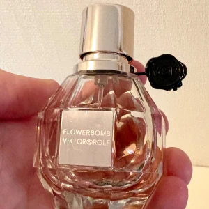 Flowerbomb Eau de Parfum by Viktor&Rolf 30 ml - En söt, feminin, blommig, fluffig och krämig vaniljparfym från Viktor&Rolf. En riktig klassiker. 30 ml, ungefär hälften kvar vilket syns på bilderna. Givetvis förvarad mörkt och svalt. 