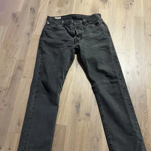 Gråa Levis 501 jeans - Säljer ett par klassiska gråa Levis 501 jeans i bra skick, använda en gång. Lite långa i benen på mig, är 1,70. Sitter lite tajt i midjan därför jag säljer. 