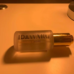Ida Warg Tanning Drops - Ida Warg Tanning Drops är veganska brun-utan-sol droppar som blandas med din vanliga ansiktskräm för en solkysst look. Flaskan innehåller 45 ml och har en elegant design med guldfärgat lock.