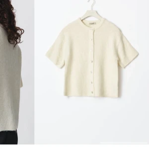 Vit stickad kofta från gina  - Säljer en söt vit stickad kofta från gina med korta ärmar och knappar framtill. Perfekt för lager-på-lager och ger en mysig känsla. Den är inte tillgänglig på butik eller i hemsidan🤍nypris-360kr jag säljer för 200kr