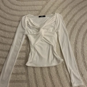 Vit långärmad topp med knutdetalj - Snygg vit långärmad topp från Bik Bok med en unik knutdetalj framtill.