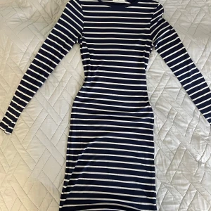 Randig klänning från Henri Lloyd - Säljer en randig klänning från Henri Lloyd i marinblått och vitt. Klänningen är långärmad och har en tight passform. Tillverkad i 100% lyocell vilket gör den superbekväm och mjuk 🤍