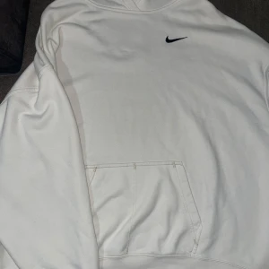oversized vit hoodie från Nike - säljer en oversized vit hoodie från Nike i storlek S. den har en klassisk design med en svart Nike-logga på bröstet och en större logga på ryggen. hoodien har en stor ficka framtill och är perfekt för en avslappnad stil. (OBS!! väldigt oversized men skön)) knappt använd