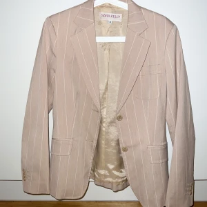 Beige kavaj - Beige kavaj med vita ränder. Mycket bra skick, använd endast ett fåtal gånger.