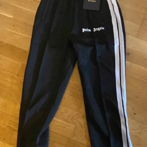 Svarta byxor från Palm Angels - Säljer ett par svarta byxor helt nya och riktigt snygga Palm Angels i storlek L, kommer med tags. 