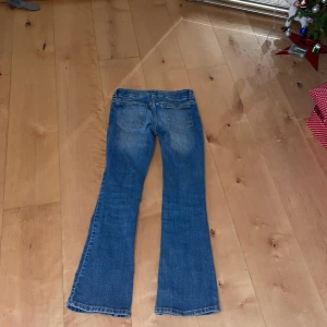 Blå bootcut jeans från H&M - Säljer ett par blå bootcut jeans från H&M i storlek 152. De är i bra skick. Man kan spänna dom i midjan.
