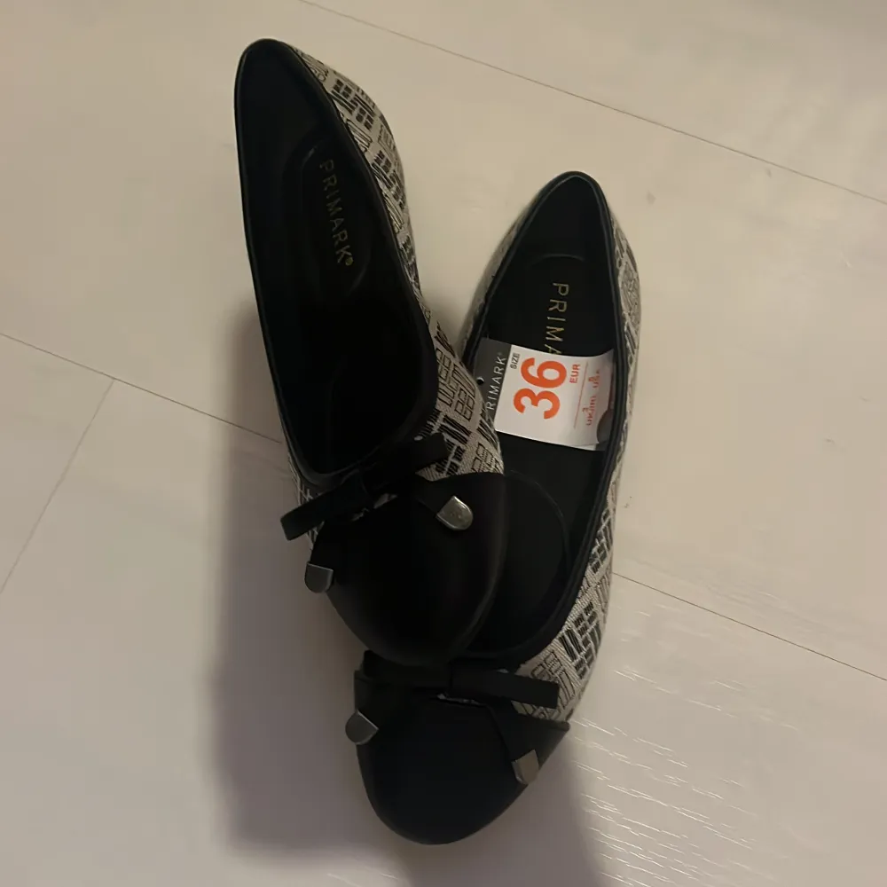 Snygga ballerinaskor i storlek 36. De har ett svart och vitt mönster med en elegant rosett på tån. Perfekta för både vardag och festliga tillfällen. Skorna är i mycket bra skick då de inte använts en enda gång och har prislappen kvar. Skorna passar storlek även storlek 38 då de är stora i storleken. . Kengät.