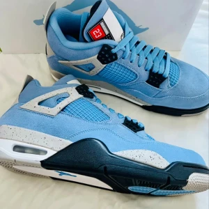 Nike Air Jordans 4s i ljusblå mocka - Snygga Nike Air Jordans i ljusblå mocka med svarta och vita detaljer. Skorna har snörning och en unik design med nummer 23 på plösen. Perfekta för den som vill sticka ut med stil.