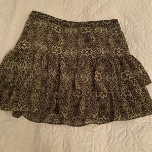 Mönstrad kjol med volanger - Säljer en superfin kortkjol med leopardmönster och volanger. Perfekt för en utekväll eller fest! Kjolen har en bekväm passform och är gjord i ett lätt material som passar bra till både vår och sommar.