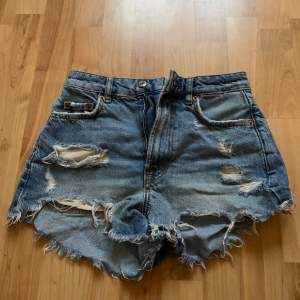 Säljer ett par coola blå jeansshorts från Zara i storlek dam 32. De har en snygg slitning och fransiga kanter för en avslappnad look. Perfekta för sommardagar eller festivaler! 🕶️