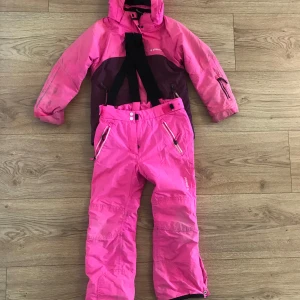 Jacka och Täckbyxa  - Jackan är i stl 122 och byxorna är i stl 134. Färg av ”lera” finns på vissa ställen. Överdragsbyxan/täckbyxans band går att ha på vilket sätt man vill, går även att ta bort helt!