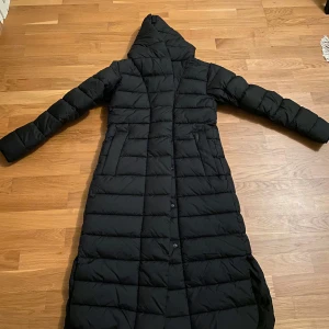 Didriksons Stella lång kappa  - Helt ny Stella kappa från Didriksons. Aldrig använd Svart stl 34 Nypris 3000 kr 