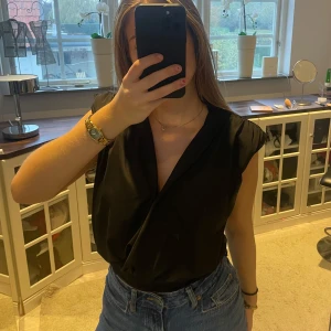 Svart blus  - Svart blus som är en body med axelvaddar❤️ Sjukt snygg!😩 Storlek S🥰