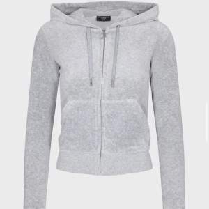 Säljer en supermjuk och bekväm grå hoodie från Juicy Couture. Perfekt för en avslappnad dag eller mysiga stunder hemma. Den har en dragkedja framtill och en klassisk huva med snören. Passar perfekt till jeans eller matchande mjukisbyxor. 🩶