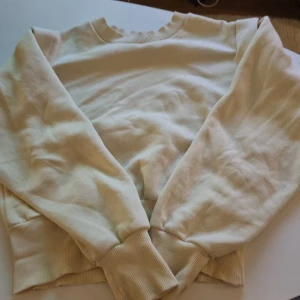 Beige tröja från Gina Tricot - Säljer en supermysig beige tröja från Gina Tricot i storlek XS. Den har långa ärmar och ribbade muddar vid ärmslut och nederkant. Perfekt för en chill dag hemma eller en promenad i parken. Tröjan är i bra skick och redo för en ny ägare! Men har en liten fläck som ni ser på sista bilden.