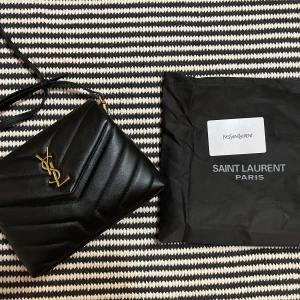 Svart YSL axelremsväska  - Använd fåtal gånger, justerbart band med gulddetaljer. (Ej äkta!)