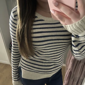 Randig stickad tröja i blått och vitt - Säljer en superfin randig tröja i blått och vitt. Den är stickad och har långa ärmar med ribbade muddar. Perfekt för höst och vinter, och den är i mycket bra skick. Passar både till vardags och lite finare tillfällen. Den är storlek XL men jag som är S upplever den som en S💕✨