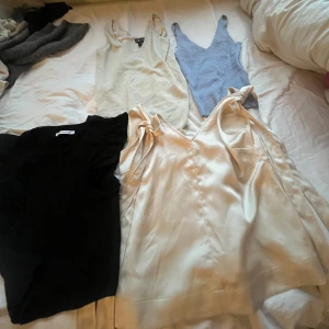 4 linne  - Säljer en snygg svart topp med volangdetaljer på ärmarna. Den är croppad och har en tight passform, perfekt för både vardag fest, med 3 andra toppar i blå och två beiga. Toppen är i mycket bra skick och passar bra till jeans eller kjol.