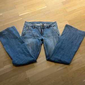 Lågmidjade Vintage jeans! - Säljer ett par snygga blå lågmidjade jeans i bra skick. De har en cool bältesdetalj baktill. De är vintage från mango! 
