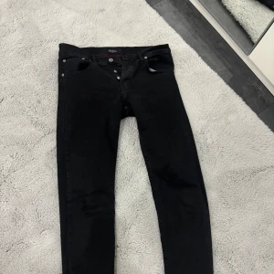 Dam! Lågmidajde svarta hugo boss jeans - Säljer ett par snygga svarta jeans från Boss i mycket bra skick. De är tighta och har en klassisk femficksdesign med knappar fram. Perfekta för både vardag och fest! Oanvända🖤 
