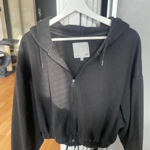 Svart hoodie med dragkedja från lager 157 - Säljer en svart hoodie från 157 i mycket bra skick. Den har en dragkedja framtill och en skön huva med snören. Perfekt för höst och vinter, och passar till både vardag och chill. Den är normal i passformen och supermjuk!