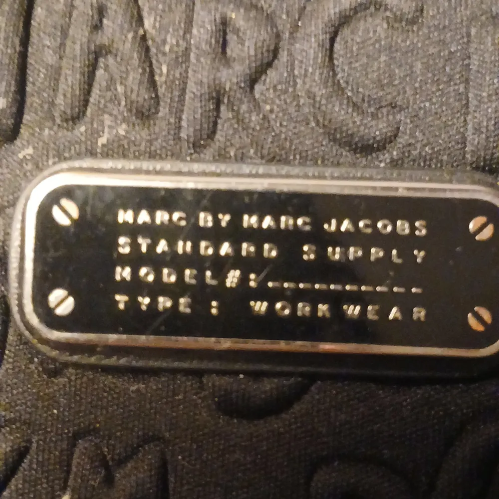 Säljer en snygg svart datorväska från Marc Jacobs. Väskan har ett präglat mönster med märkesnamnet och en metallplatta med text. Den är perfekt för att skydda din laptop och har en dragkedja för säker förslutning. Stilren och praktisk för både arbete och skola. Jag säljer den för den är för liten för min dator och jag har köpt den så jag vet att den är äkta. . Övrigt.