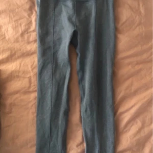 Blå träningsbyxor  - Säljer ett par snygga blå träningsbyxor i bra skick. De är högmidjade och har en tight passform. Materialet är mjukt och stretchigt, vilket gör dem superbekväma att ha på sig. Passar perfekt till en oversized tröja eller hoodie!