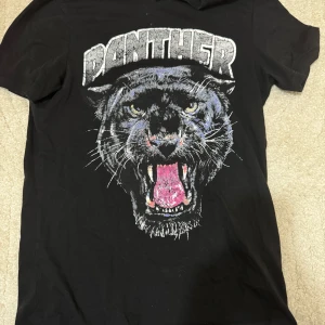 Svart t-shirt med pantermotiv - Cool svart t-shirt med ett stort tryck av en panter på framsidan. Köpt på Nelly