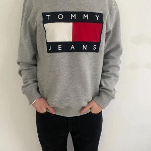 Tommy Hilfiger tröja - Säljer en grå Tommy Hilfiger tröja. Den är lite tjockare och passar superbra till hösten 🍂 och vintern ❄️. Tröjan är i storleken M. Modellen på bilden är 180 och väger cirka 70 kg. Tveka inte att höra av dig vid funderingar eller om du vill ha fler bilder. 👊 
