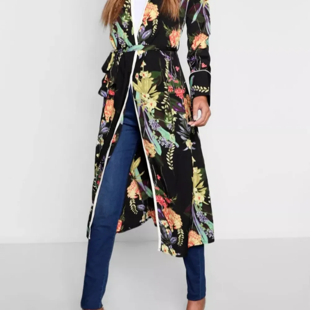 En häftigt & snygg kimono i blommönster med knytband . Denna kimono är så snygg & passar bra att dra på över klänningar, jeans och jumpsuits och passar för alla tillfällen. Maskintvätt. 100 % polyester. Sparsamt använd . Kostymer.