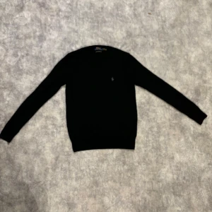 Stickad Ralph lauren tröja - Säljer nu min Ralph lauren tröja i färgen svart! Tröjan är av materialet marinoull vilket är väldigt stilrent och bekvämt. Köpt i butik för 2100kr. Storlek xs och passar dig som är runt 160-170cm lång.  Skriv om du har några frågor!