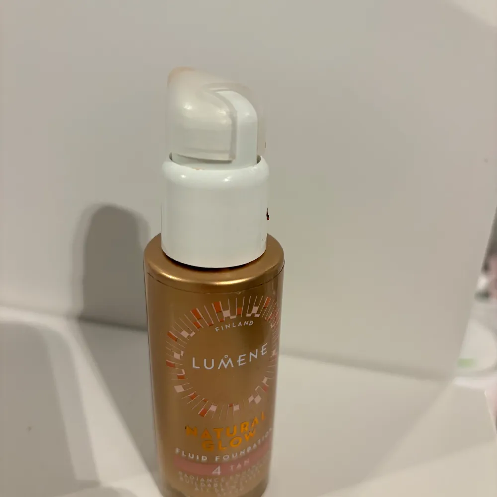 Säljer en flaska Lumene Natural Glow Foundation i nyansen 4 Tan. Den ger en naturlig lyster och jämn hudton. Perfekt för en solkysst look! Flaskan har en praktisk pump för enkel applicering.. Skönhet.