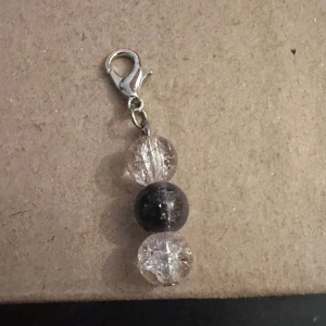 Nyckelring med pärlor - Snygg nyckelring med en kombination av klara och mörka pärlor. Den har en praktisk karbinhake i silverfärg för enkel fastsättning. Perfekt som en liten accessoar för väskan eller nycklarna.